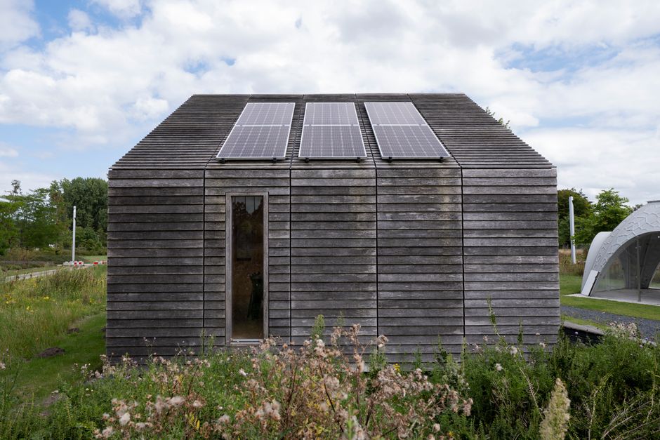 Tuin van energie-efficiënt zomerhuis met windturbine. Tuin van energie-efficiënt zomerhuis met windturbine.